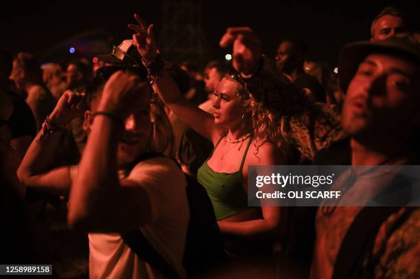 Festivalgoers listen to British duo The Chemical Brothers perform their DJ set in the Arcadia area on day 3 of the Glastonbury festival in the...