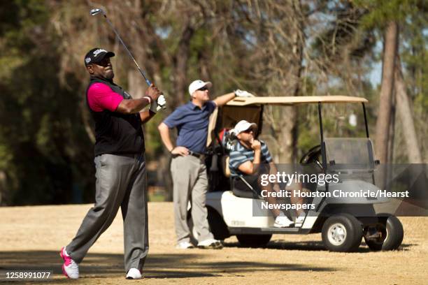 Former Dallas Cowboys and Hall of Fame running back Emmitt Smith hits a fairway show, with Mark Button, center, and Vince Scudiero looking on, while...