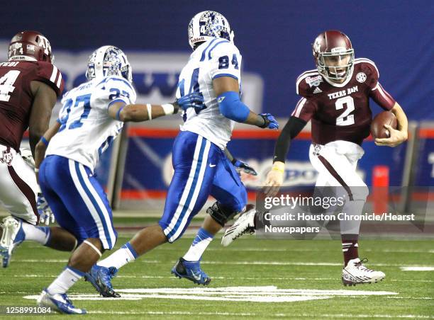 Texas A&M quarterback Johnny Manziel is chased out of the pocket by Duke defensive end Kenny Anunike and cornerback DeVon Edwards during the second...