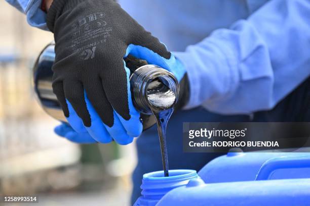Technician from state-owned Petroecuador takes crude oil samples from an oil well in the Ishpingo field in Yasuni National Park, northeastern...