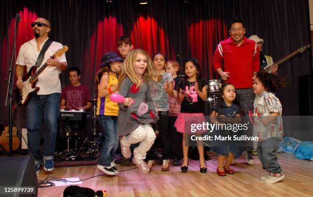 Members of Ozomatli perform with children during Musical Explorations: Ozokidz at The GRAMMY Museum on February 12, 2011 in Los Angeles, California.