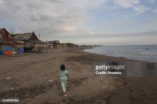 Girl walk at a village affected by rising sea level in Galesong, Takalar Regency, Indonesia, on June 20. Coastal abrasion due to the crashing of the...