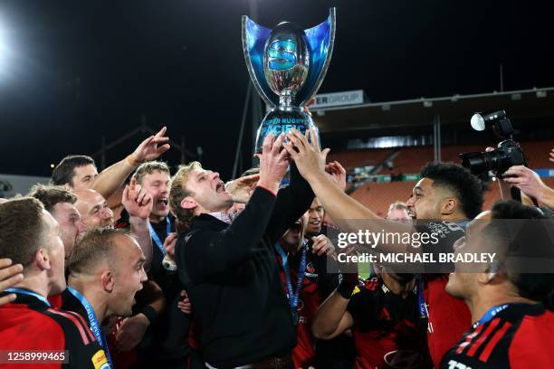 Crusaders' coach Scott Robertson and players celebrate with the winning Super Rugby Pacific trophy after the Super Rugby Pacific final match between...