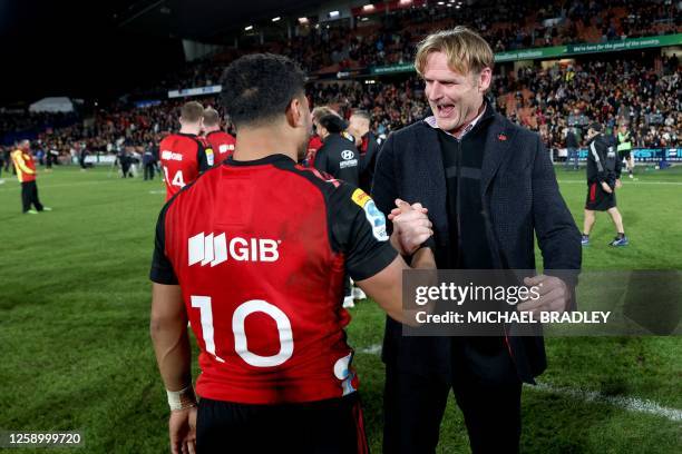 Crusaders head coach Scott Robertson gives a hug to Richie Mo'unga after winning the Super Rugby Pacific final match between the Chiefs and Crusaders...