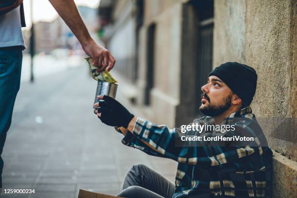 senzatetto che riceve denaro - elemosina oggetto religioso foto e immagini stock