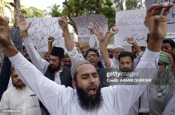 Activists of a religious party Jamiat Ulema-e-Pakistan chant slogans during a protest in Karachi, 11 November 2002. The protesters are demanding the...