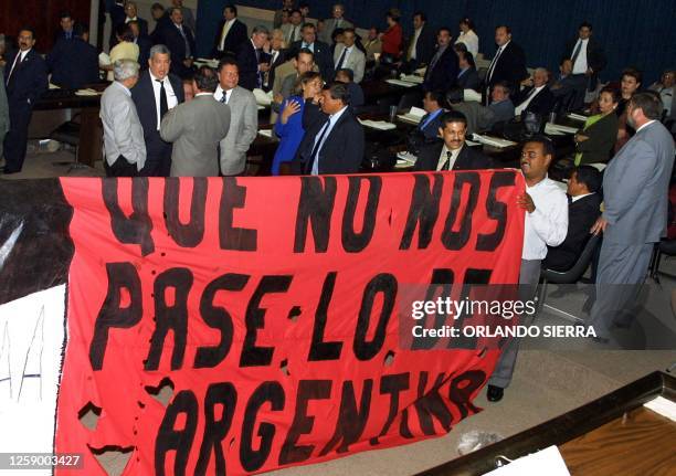 Members of the Unified Democratic Party hold a banner in protest of the "Law of Financial Balance and Social Protection" at the National Congress in...