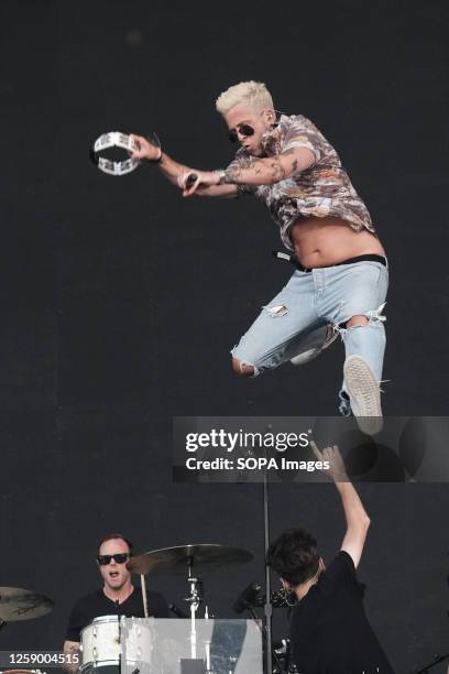 Drummer Eddie Fisher plays drums as Ryan Tedder, lead singer and guitarist with American indie alternative pop rock band OneRepublic, jumps off the...