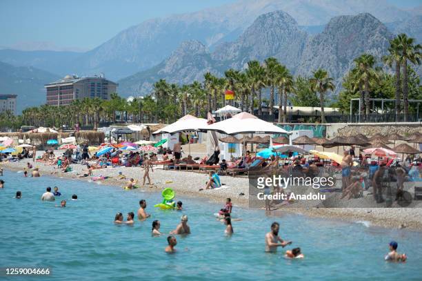 Citizens and tourists spend time at Konyaalti and Lara beaches ahead of eid holiday to cool off as temperatures 36 celsius degrees in Antalya,...