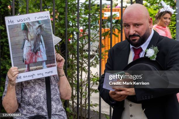 Racegoer passes an animal rights campaigner protesting outside Ascot racecourse on the fifth day of Royal Ascot on 24 June 2023 in Ascot, United...