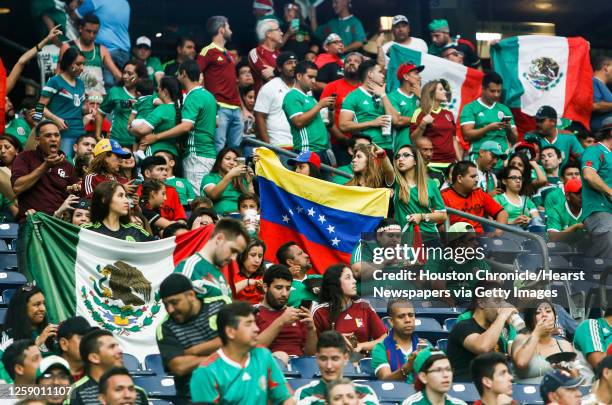 Fans of Mexico and Venezuela wave their respective flags before a Copa America Centenario group C soccer match on Monday, June 13 in Houston.