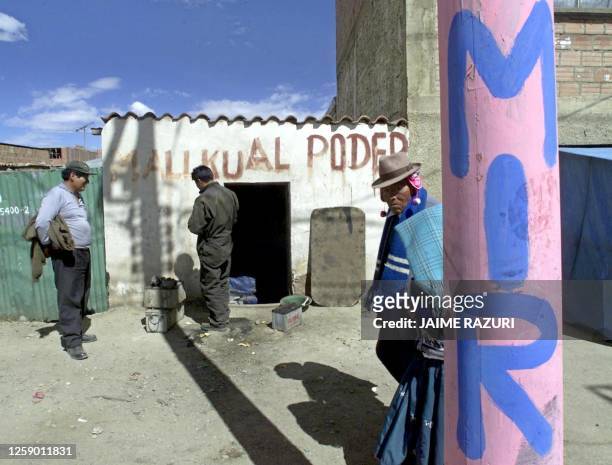 Pedestrian passes in front of a post that has been painted with political propaganda in the district of El Alto, La Paz, 29 June 2002. Un ciudadanos...
