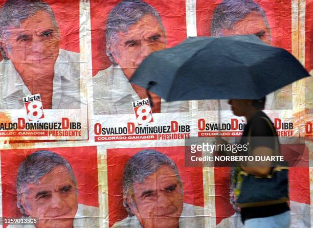 Woman walks by campaign posters of candidate Osvaldo Dominguez, 21 December 2002, in Asuncion, Paraguay. Nicanor Frutos and entrepeneur Osvaldo...