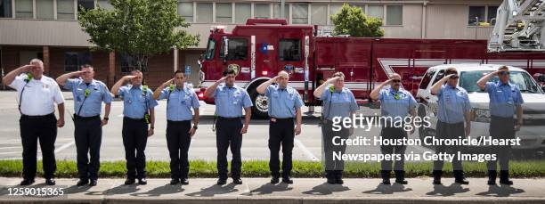 Line of Houston firefighters salute as the body of fallen Houston Police officer Jason Knox is escorted in a procession to the funeral home on...