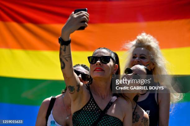Participants take a picture in front of a rainbow flag during the annual Pride Parade to show support for members of the LGBT community, in Milan on...