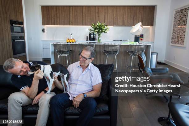 Tim Kollatschny, left, and Steven Goldberg sit with their dog, Chloe, in the living room at their home in The Mond at The Museums Wednesday, Nov. 18,...