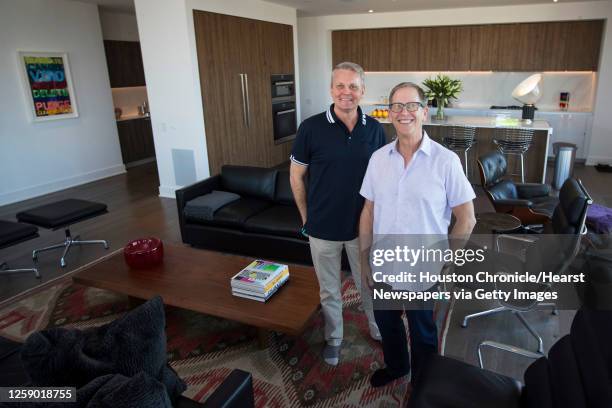 Tim Kollatschny, left, and Steven Goldberg stand in the living room of their home at The Mond at The Museums Wednesday, Nov. 18, 2020 in Houston.