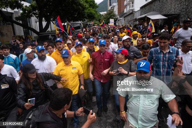 Henrique Capriles, opposition leader and former governor of the State of Miranda, center, marches with supporters before officially registering for...