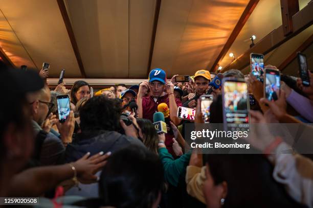Henrique Capriles, opposition leader and former governor of the State of Miranda, center, speaks to member of the media after officially registering...