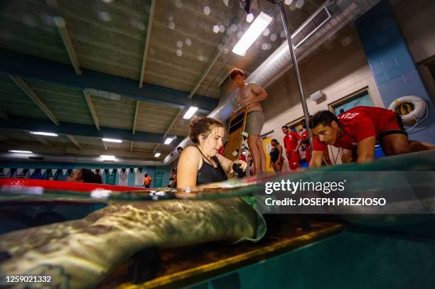 Youth lifeguards take part in a Swimposium where they practice skills to save people in the water in Waltham, Massachusetts on June 24, 2023. The...