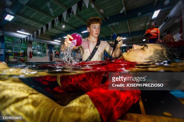 Youth lifeguards take part in a Swimposium where they practice skills to save people in the water in Waltham, Massachusetts on June 24, 2023. The...