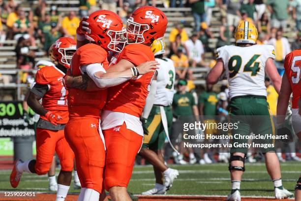 Sam Houston State quarterback Eric Schmid and tight end Rowdy Godwin embrace after Schmid scored the game-winning touchdown on a 6-yard run against...