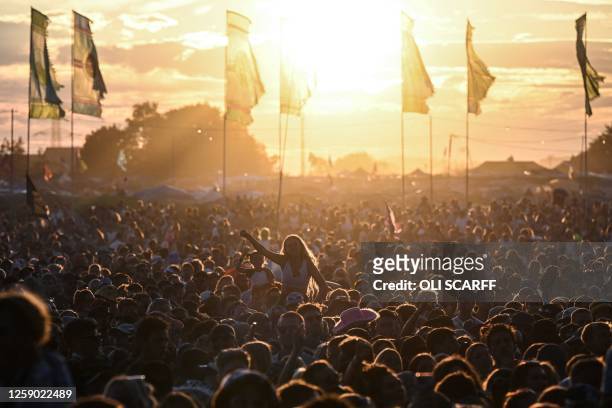 Festival goers cheer and listen to the concert on The Other Stage on day 4 of the Glastonbury festival in the village of Pilton in Somerset,...