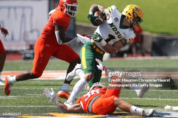 North Dakota State wide receiver Christian Watson is tripped up for a loss by Sam Houston State defensive back Braiden Clopton during the third...