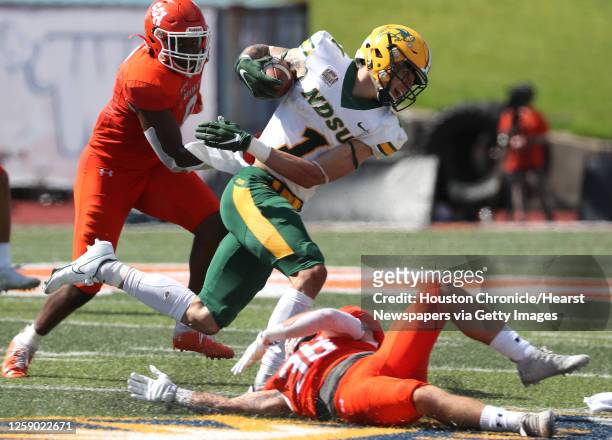 North Dakota State wide receiver Christian Watson is tripped up for a loss by Sam Houston State defensive back Braiden Clopton during the third...