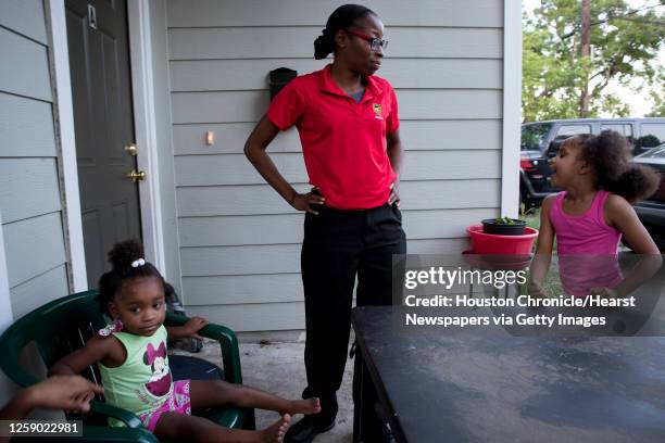 Janelle Ivy, a rent relief recepient, stands outside her sister's house with her daughters Chanell Jackson left, and McKennah Torres as she watches...