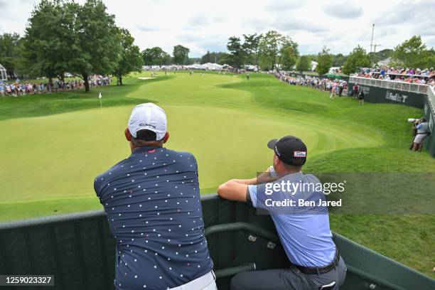 Justin Thomas and Gary Woodland watch Rickie Fowler play his next shot on the ninth hole during the third round of the Travelers Championship at TPC...