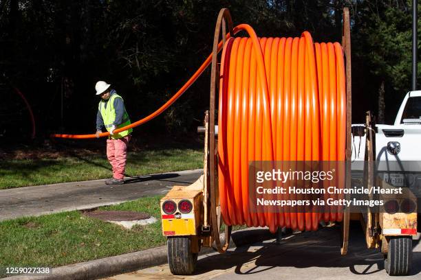 Carlos Ochoa guides interduct into the ground as work by EZEE Fiber continues on installing fiber to build a high speed internet network in Carlton...