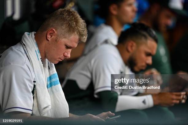 Chase Anderson of the Colorado Rockies reviews tape on a tablet in the dugout in the fourth inning of a game against the Los Angeles Angels at Coors...