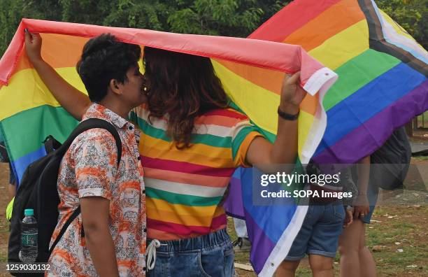 Participants with rainbow coloured flag kiss during the pride parade. June is celebrated as LGBTQ pride month, creating awareness about their LGBTQ...
