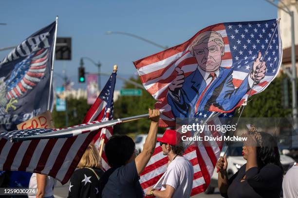 Supporters of former U.S. President Donald Trump wave flags near passing traffic during the Beverly Hills Freedom Rally on June 24, 2023 in Beverly...