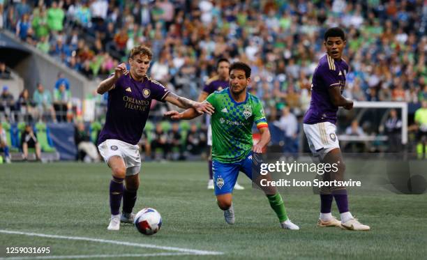 Orlando City defender Michael Halliday and Seattle Sounders midfielder Nicolás Lodeiro fight for the ball during an MSL match between the Seattle...