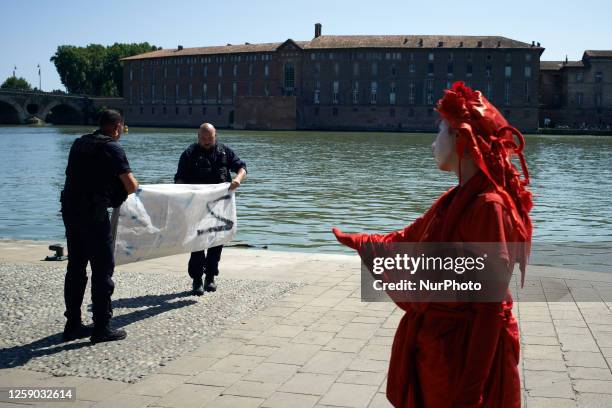 Red Rebel mourns the confiscation by policemen of the banners. Activists from XR put a giant banner reading 'Toulouse waters contaminated, who's...