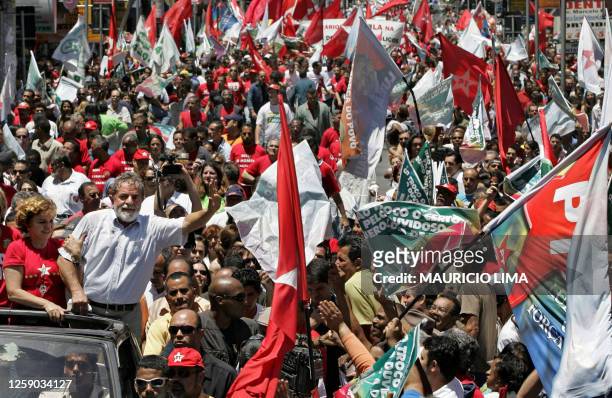 Brazil's President and reelection candidate Luiz Inacio Lula da Silva , of the Workers' Party , gestures to supporters next to his wife Marisa...