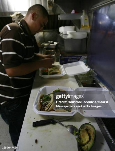 Jesse Salinas of McAllen, Texas prepares an order of tacos in the Taqueria Sanchez mobile taco truck on Veterans Memorial Boulevard in Metarie,...