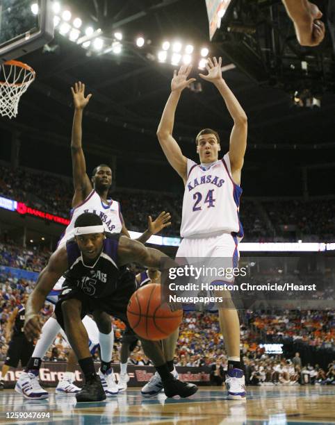 Kansas' Julian Wright and Sasha Kaun look towards a referee as Kansas State's David Hoskins chases a loose ball during the second half of Phillips 66...