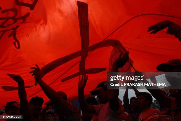 Supporters of the Communist Party of Nepal with the communist "Hammer and Sickle" take part in celebrations marking the victory of unseen former...