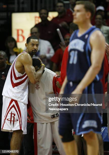 The Houston Rockets Juwan Howard hugs teammate John Lucas as the Utah Jazz' Matt Harpring walks by near the end of the fourth quarter of game five of...