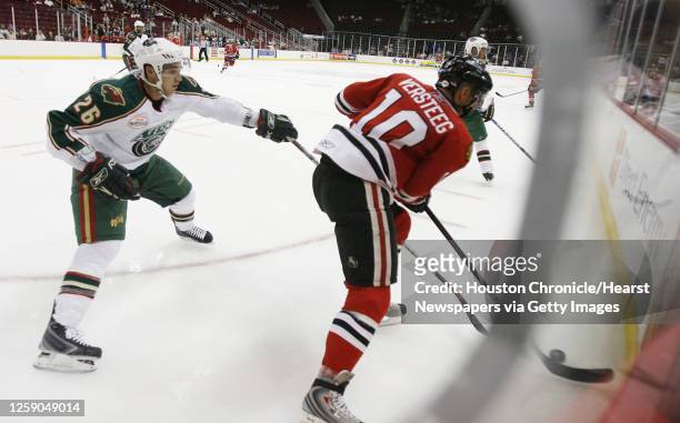 The Houston Aeros Maxim Noreau attempts to pull the puck away from the Rockford Icehogs Kris Versteeg during the second period of the AHL game at the...