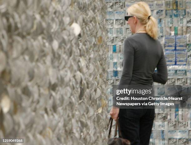 Janice Thomas looks over the Beer Can House during the Orange Show Center for Visionary Art's official public opening of the Beer Can House created...