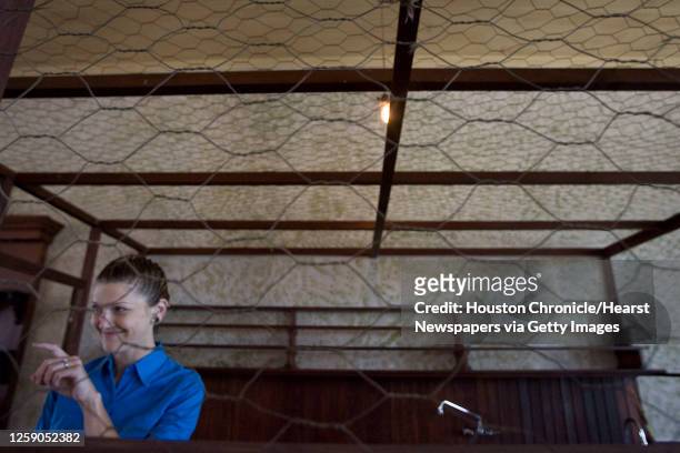 Bar tender Angela Sanders waves to a toddler from the chicken wire serving area in the upstairs dance hall during a keg tapping party at Sengelmann...
