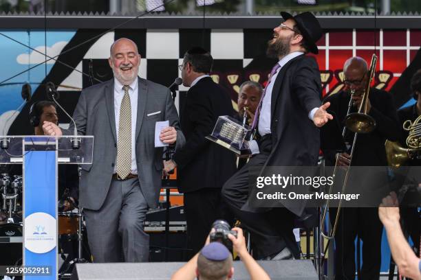 President of the Chabad Jewish Education Centre, Rabbi Yehuda Teichtal dances on stage with The Israeli Ambassador to Germany Ron Prosor during Pears...