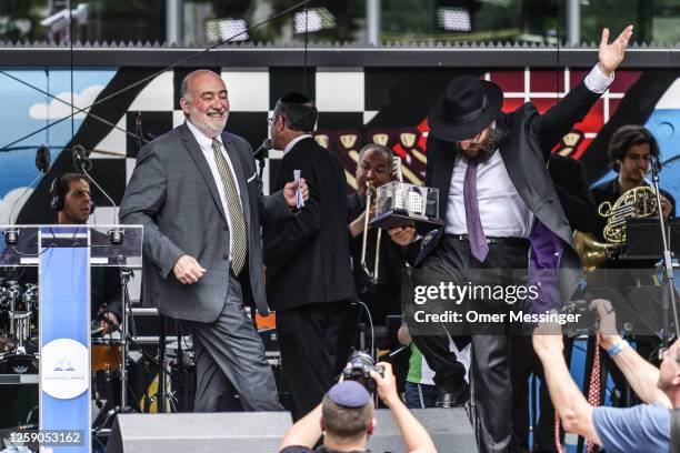 President of the Chabad Jewish Education Centre, Rabbi Yehuda Teichtal dances on stage with The Israeli Ambassador to Germany Ron Prosor during Pears...