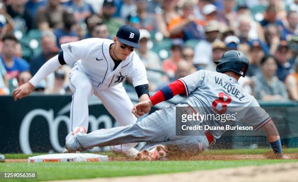 Christian Vazquez of the Minnesota Twins beats the tag from third baseman Nick Maton of the Detroit Tigers, advancing on a fly-out by Edouard Julien,...