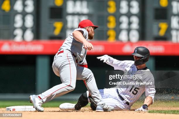 Randal Grichuk of the Colorado Rockies slides safely to second base ahead of a tag attempt by Brandon Drury of the Los Angeles Angels after hitting a...