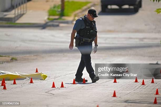 Evidence markers filled the street as police were investigating the scene after three people died and five were injured following a shooting early...